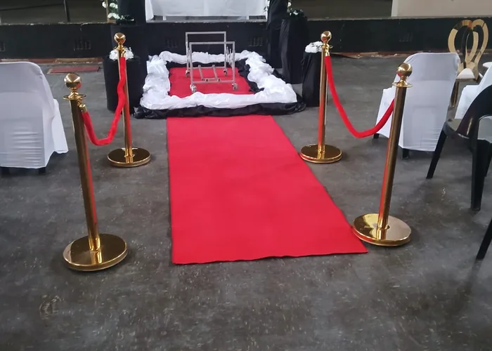 A chapel prepared with red carpet and gold stanchions