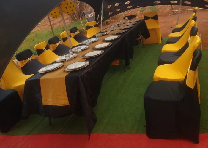 A tent laid out with black and gold table settings