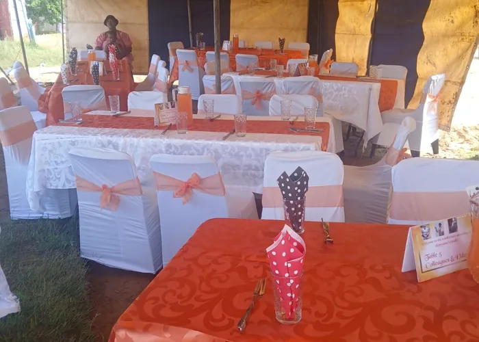 Tables laid with orange and white settings for a family gathering